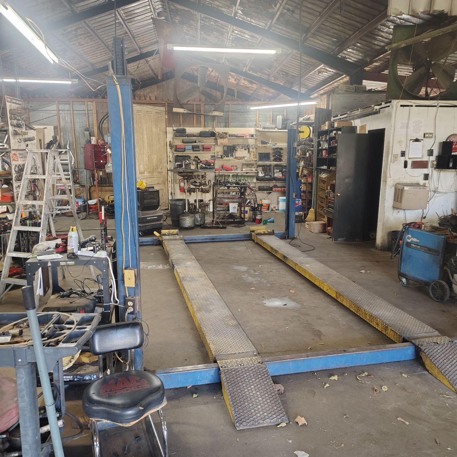 Inside Check Auto Repair in Athens, TX, with the auto lift in the middle of the bay